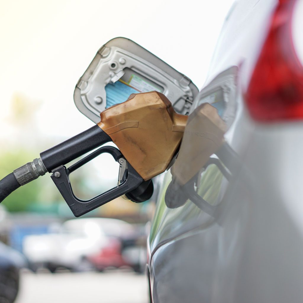 A car is filling up at the gas pump. Poor gas mileage happens when you ignore alignment issues. 