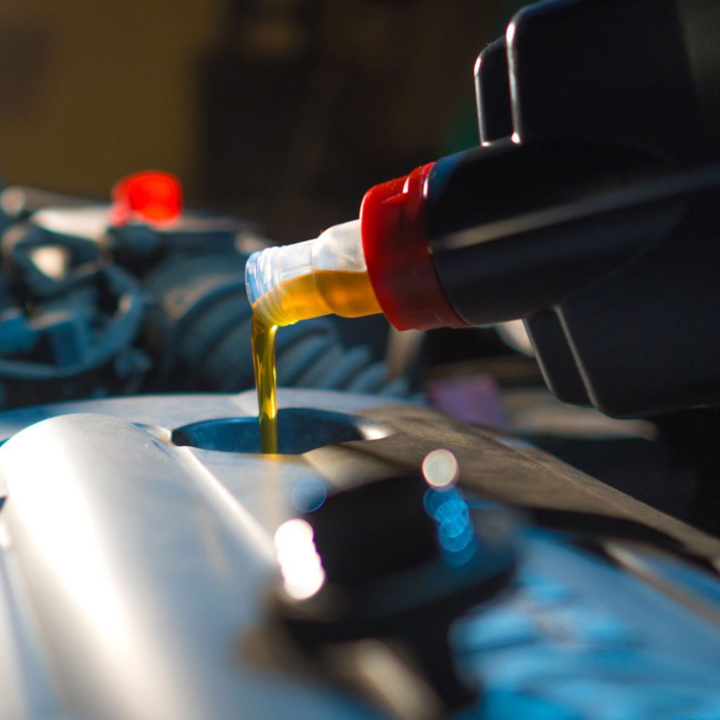 A bottle of synthetic oil is poured into an engine following an oil change in Albuquerque. 