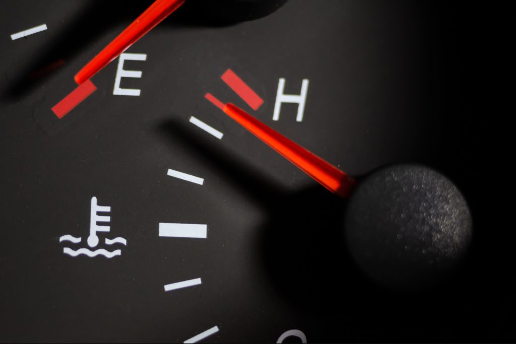 A temperature gauge in a vehicle's dashboard with the needle in the red zone to indicate it's time to visit a radiator repair technician in Albuquerque. 