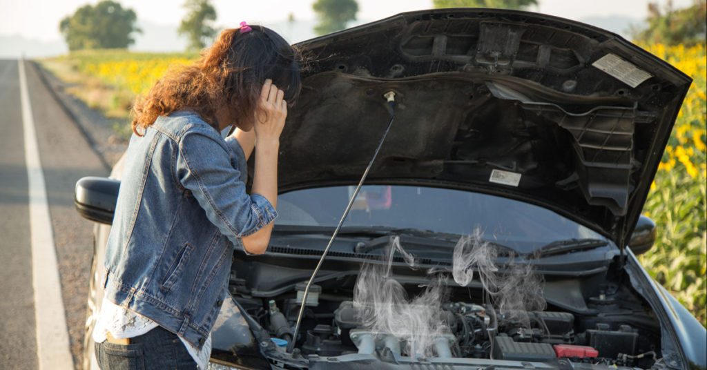 A woman calls for help on her cell phone while stranded along the side of the road with a steaming radiator. Radiator repair in Albuquerque is necessary if your radiator starts spitting steam. It means it can't cool the engine properly.