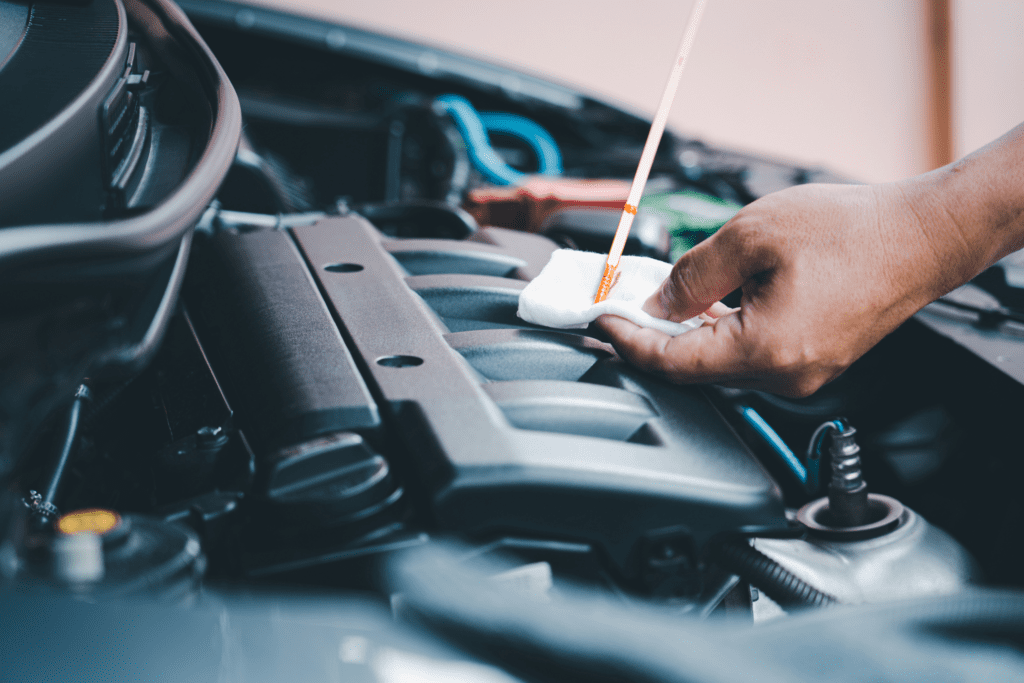 A man checks his engine oil in his car to determine if he has a leak that requires engine repairs in Albuquerque. 