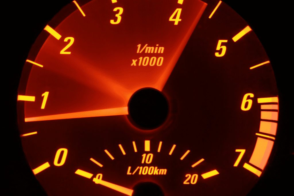 A speedometer in the dash of a foreign vehicle. 