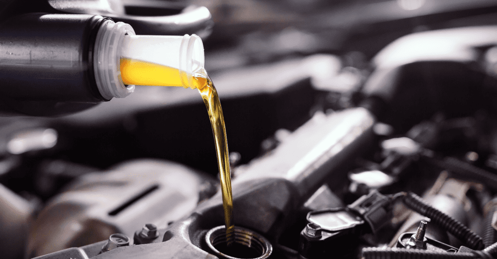 Fleet vehicle oil changes require the right type of oil. A mechanic pours engine oil into a fleet vehicle during an oil change. 